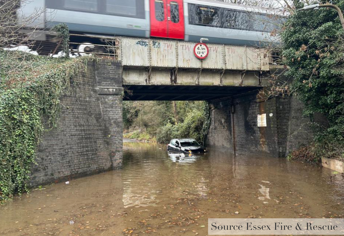 Car Stuck in water under a train bridge 