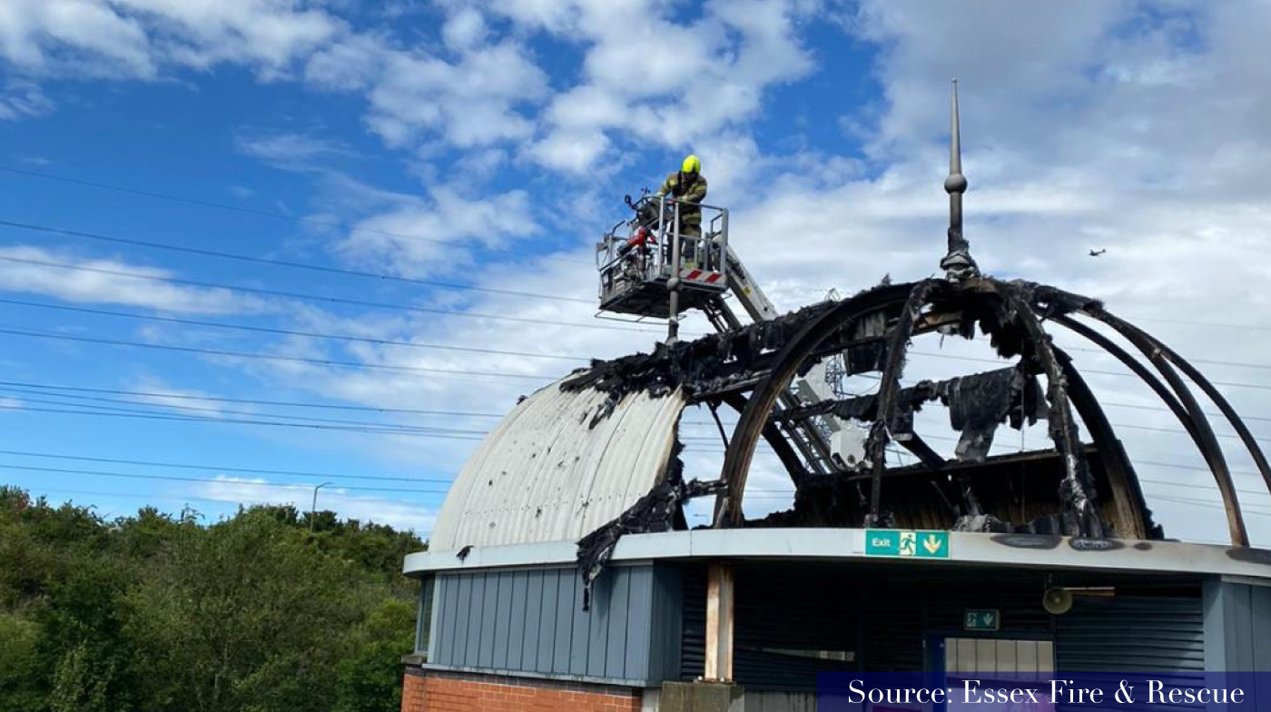 firefighters on lifting ramp over looking burnt out stairwell